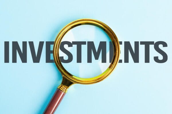 Successful business investments. Investment search concept. Magnifying glass over text - investments.